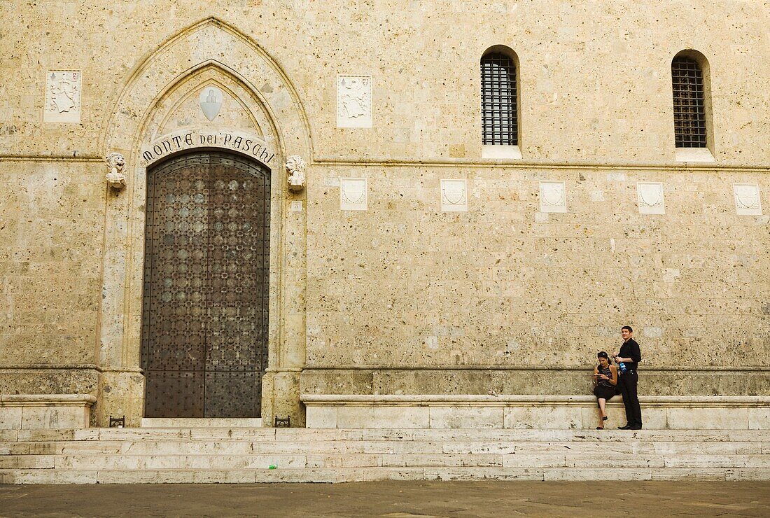 Couple Outside Building In Siena; Tuscany, Italy