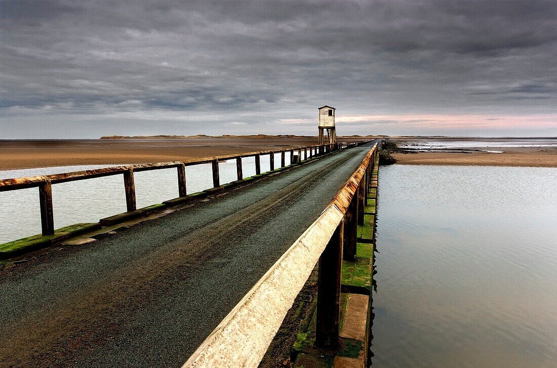 A Road Going Over Water Towards A Beach; Northumberland,England