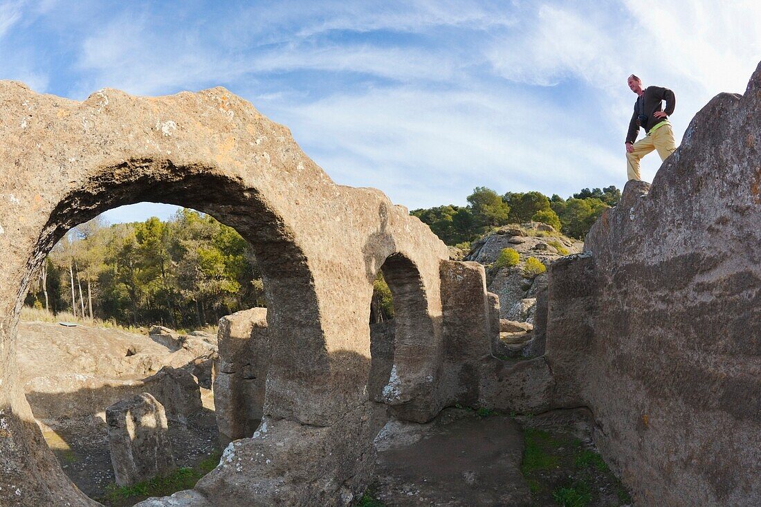 Ein Mann schaut über Steinruinen; Andalusien, Spanien