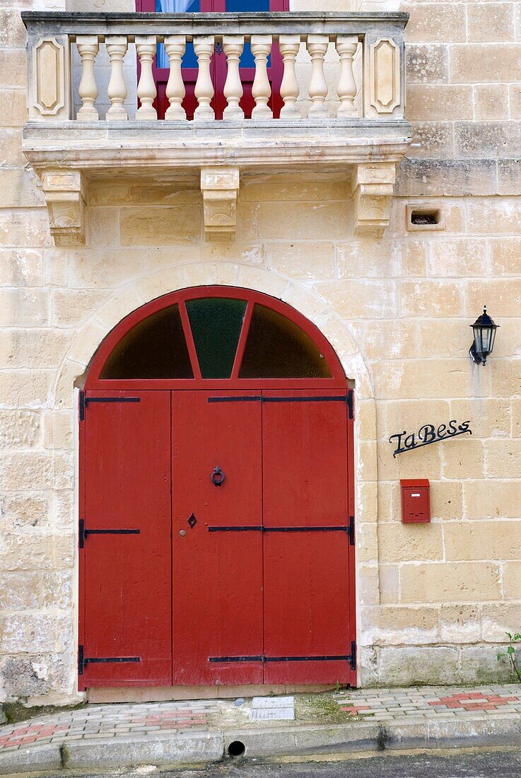 Eine rote Tür an einem Steingebäude