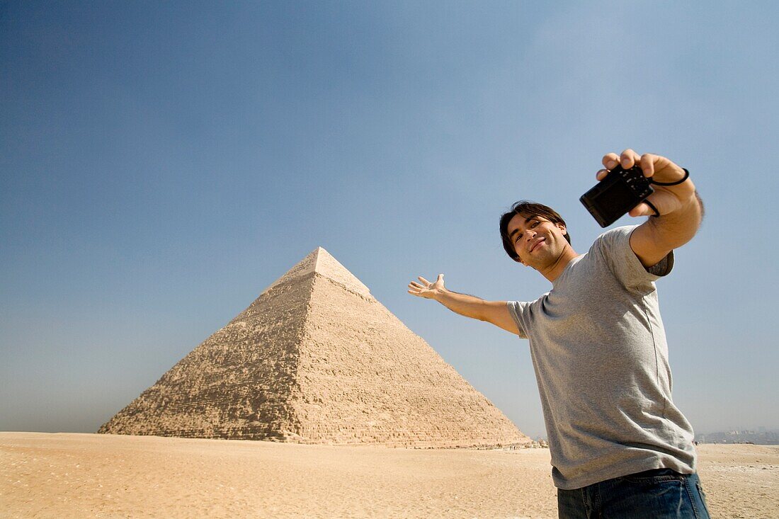 Man Taking A Picture Of Himself With Pyramid In Background
