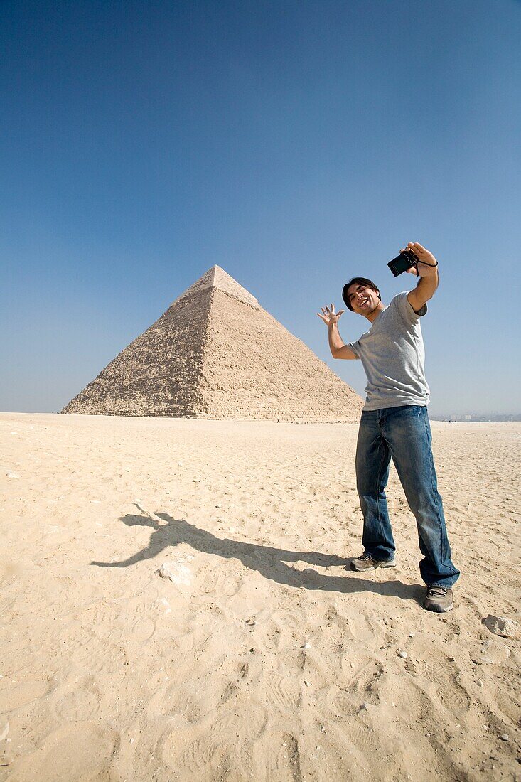 Mann, der ein Bild von sich selbst mit Pyramide im Hintergrund macht