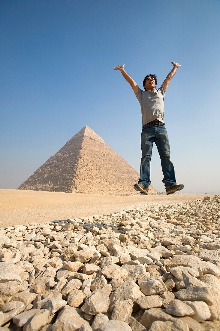 Man Jumping In Air With Pyramid In Background