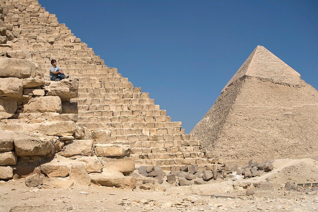 Man Sitting On Part Of A Pyramid In The Desert