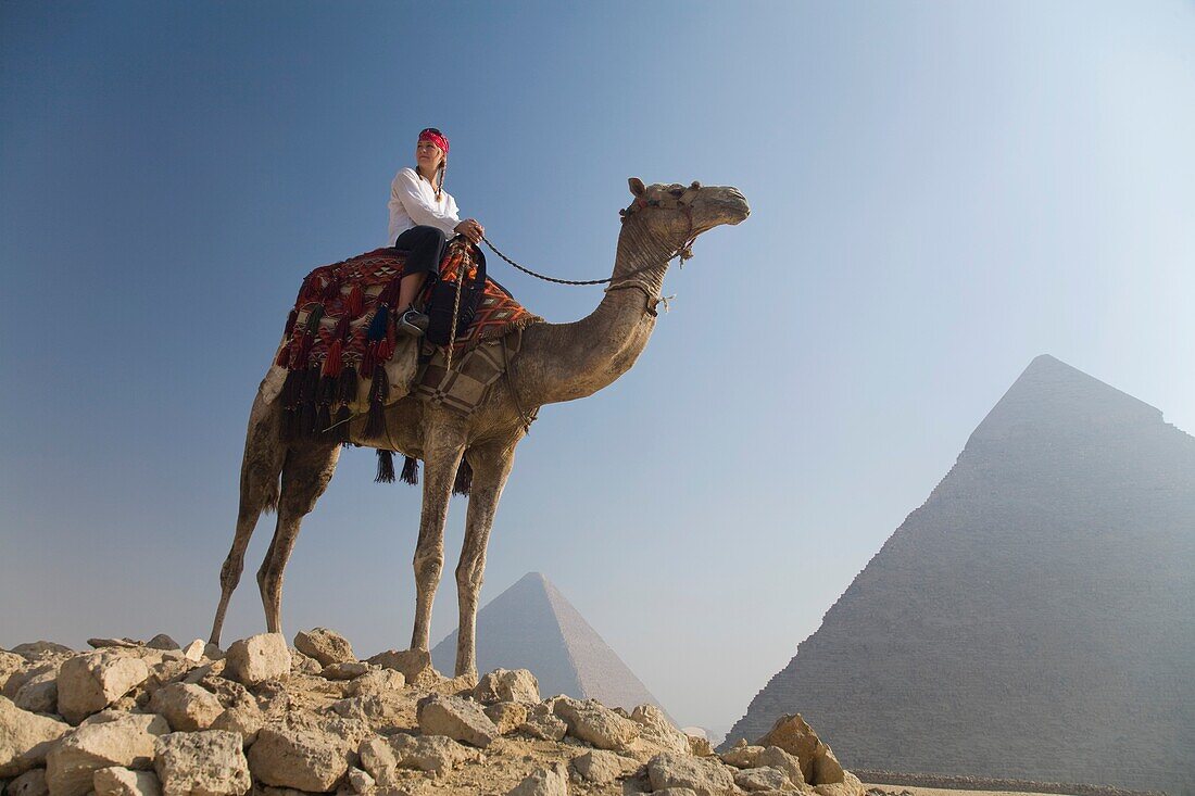 Junge Touristin auf einem Kamel bei den Pyramiden von Gizeh; Kairo, Ägypten, Afrika