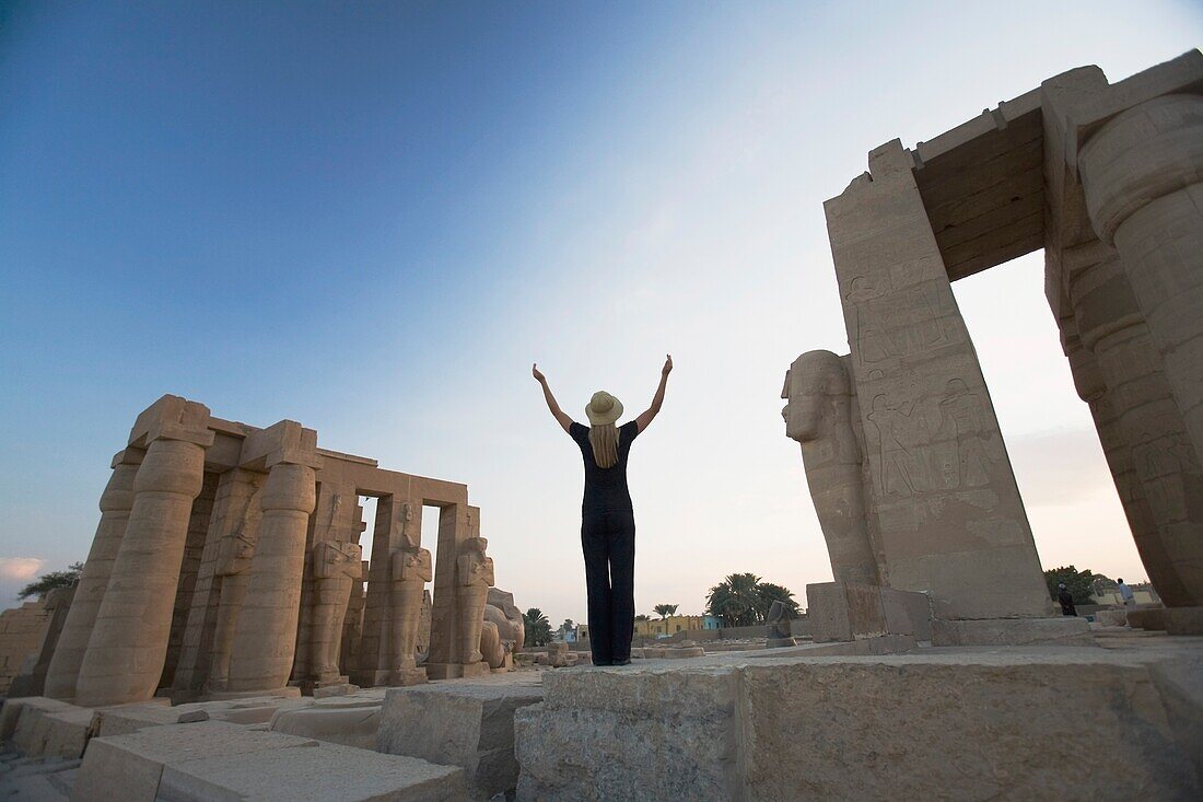 Touristin mit erhobenen Armen am Ramesseum, Luxor, Niltal, Ägypten