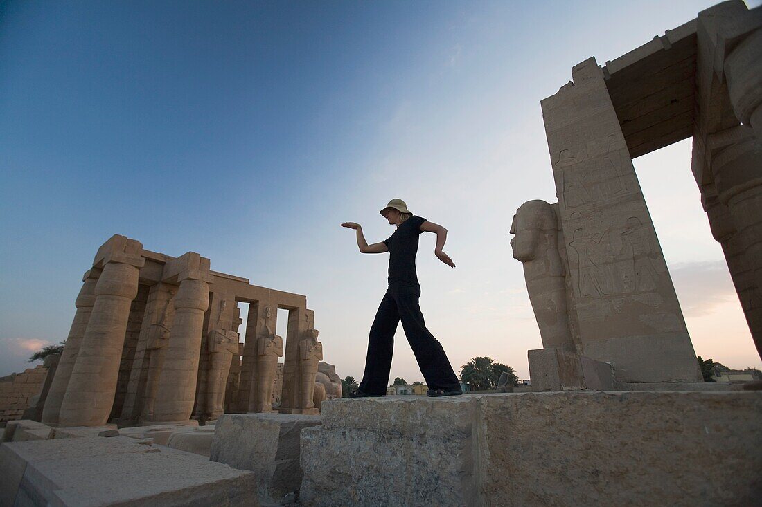 Woman Tourist Walks Like An Egyptian At The Ramesseum, Luxor, Nile Valley, Egypt