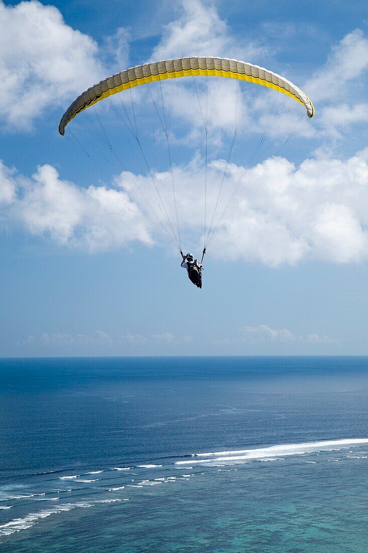 A Paraglider Soars Free Over The Cliffs And Beaches Of The Bukit Peninsula In Bali, Indonesia