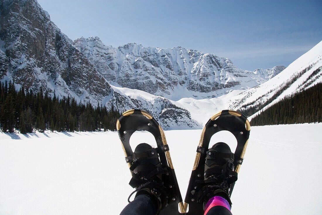 Banff National Park, Alberta, Canada; A Pair Of Snowshoes With A Snow-Covered Taylor Lake