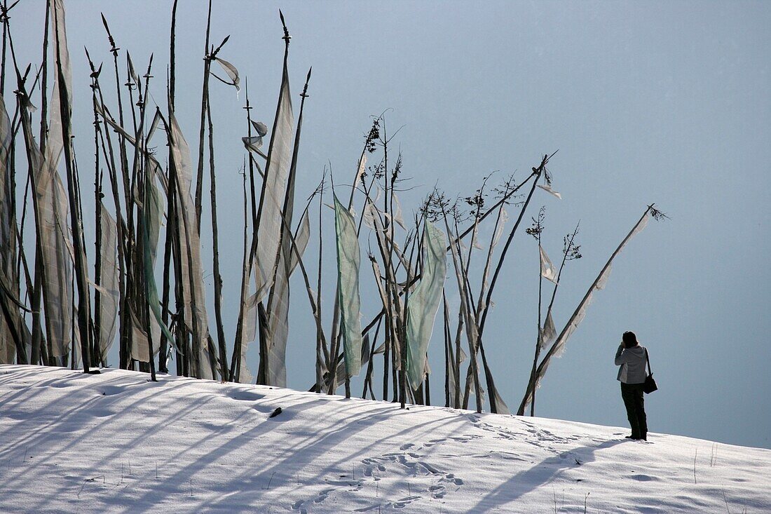 Tourist bei buddhistischen Gebetsfahnen auf einem Berg