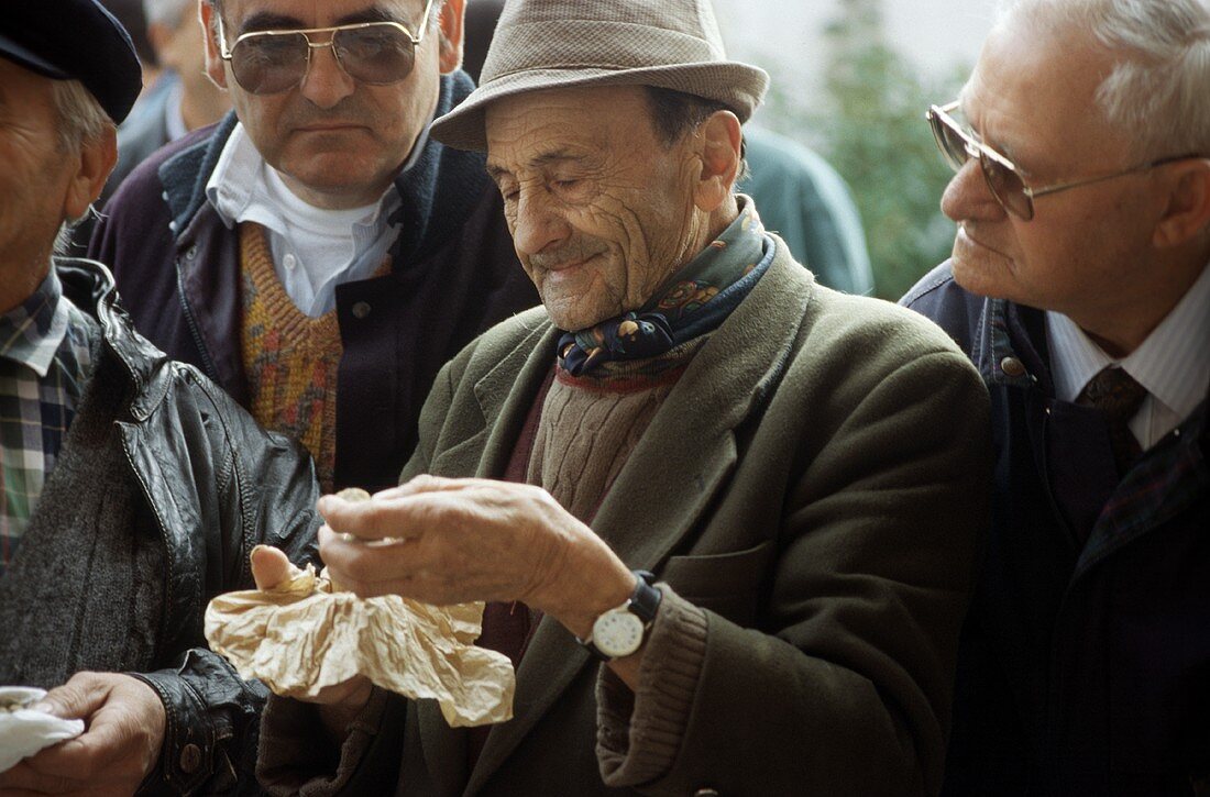 Männer prüfen Trüffel auf dem Trüffelmarkt in Alba