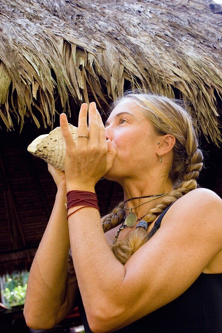 Woman Blowing Through A Conch Shell