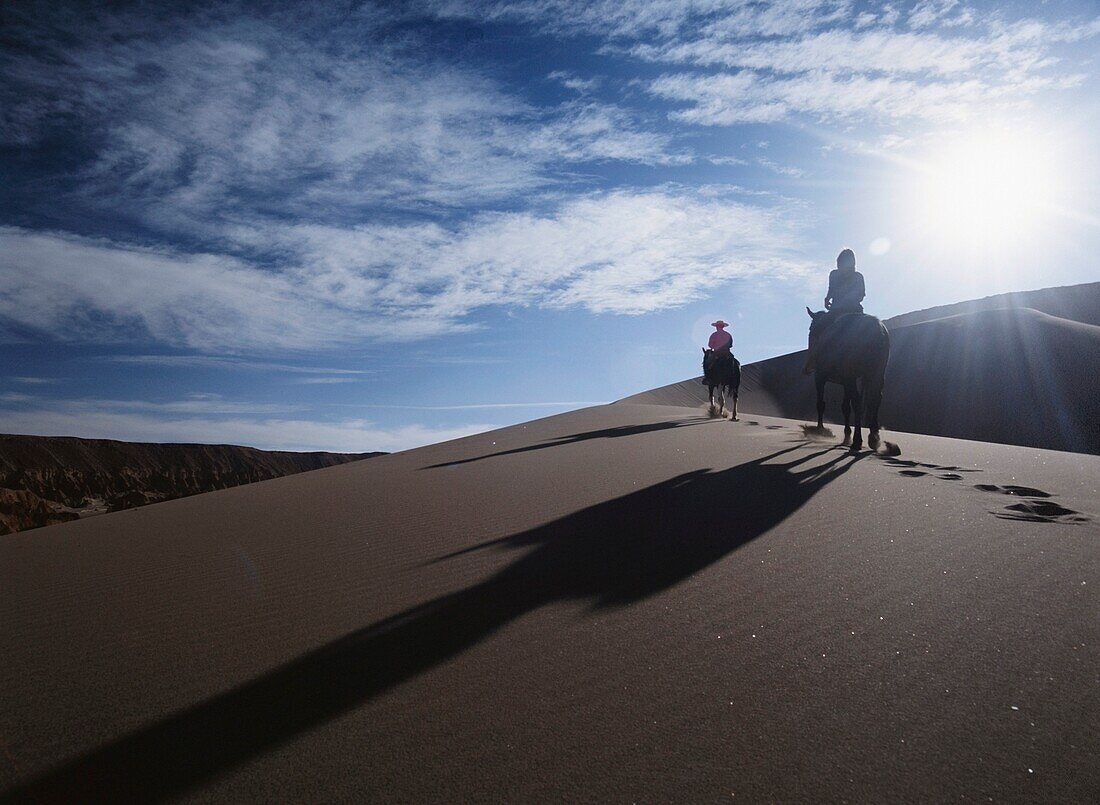 Horseback Riders In Silhouette On Sand Dunes
