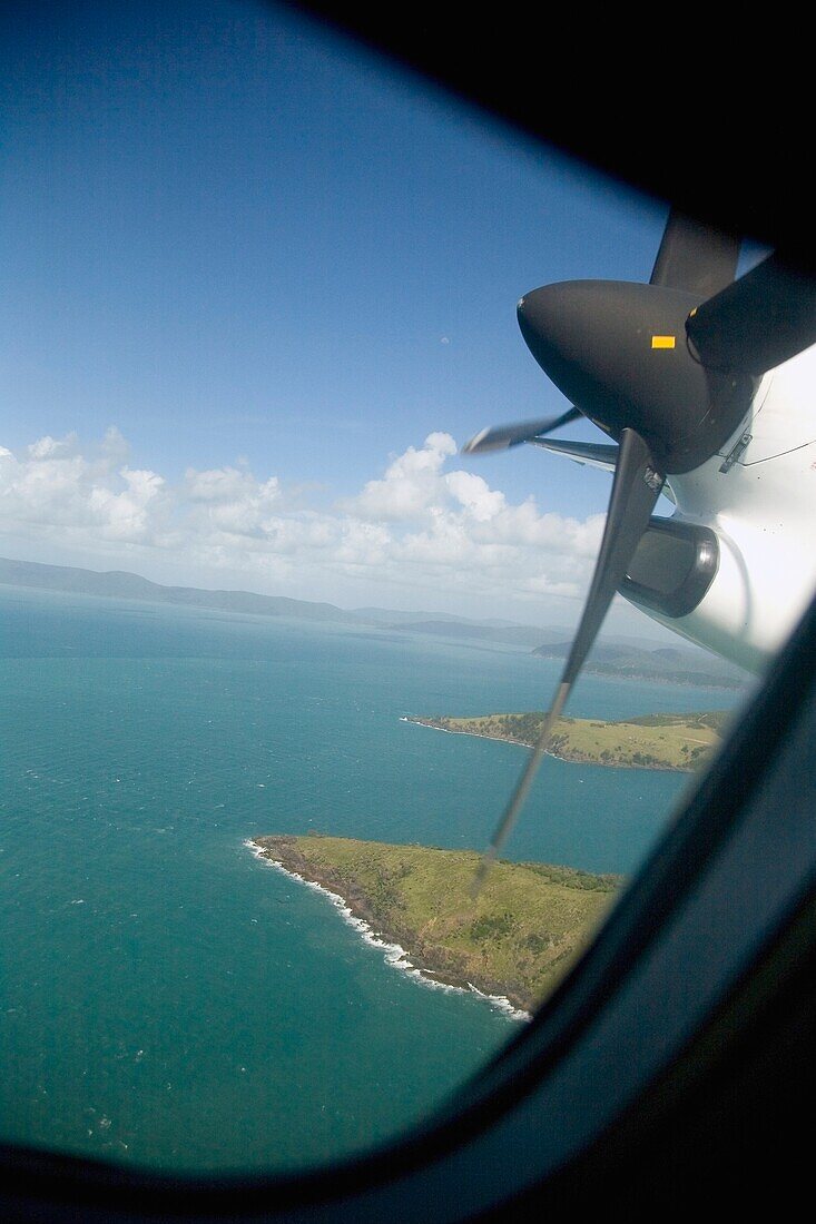 Blick durch ein Flugzeugfenster auf tropische Inseln