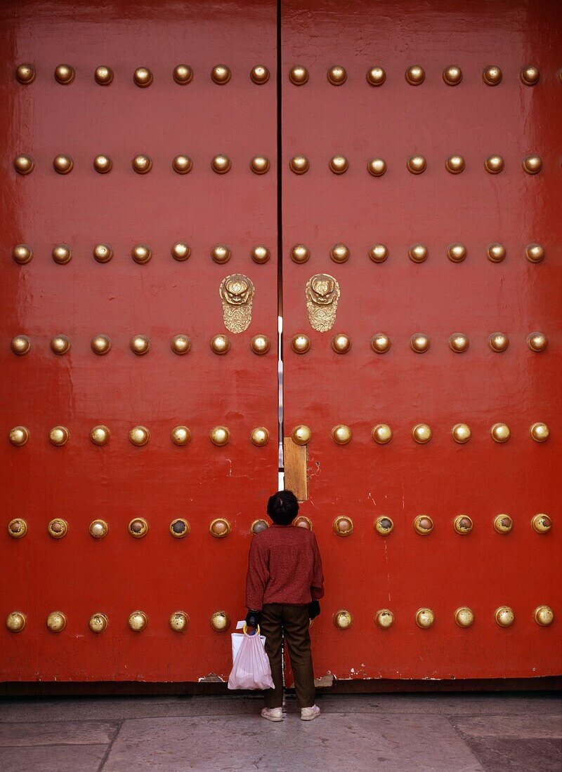 Person Peeking Through The Main Gates To The Forbidden City