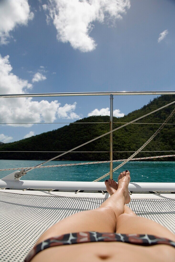 Sonnenanbeterin im Bikini beim Sonnenbaden auf einem Segelboot, tiefer Blickwinkel
