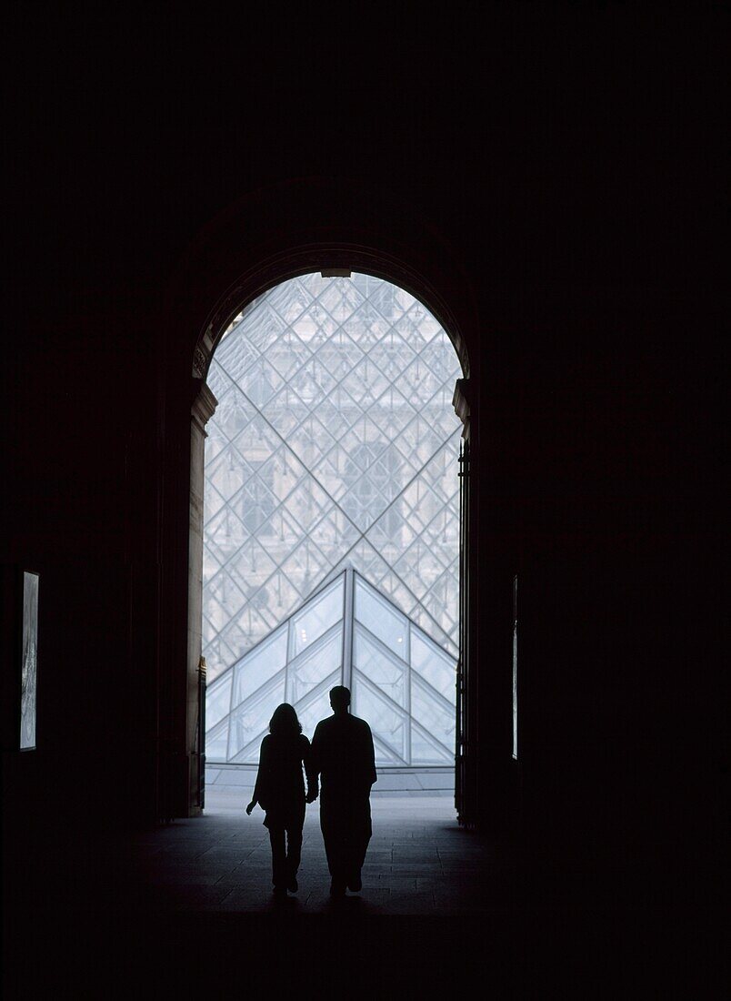 Ein Paar auf dem Weg zur Pyramide des Louvre-Museums