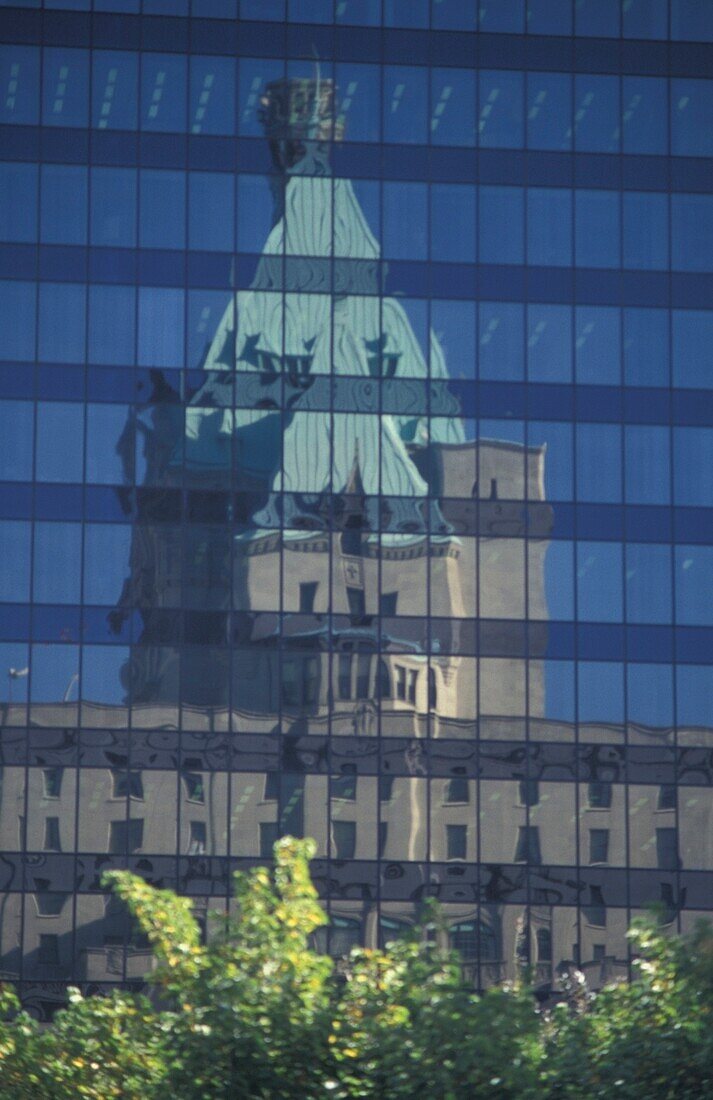 Traditionelles Gebäude spiegelt sich in einem modernen Wolkenkratzer