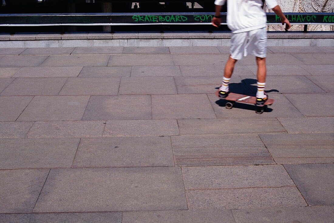 Junge fährt Skateboard auf dem Bürgersteig