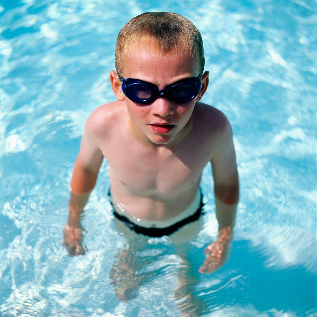 Junge mit Schwimmbrille im Schwimmbad