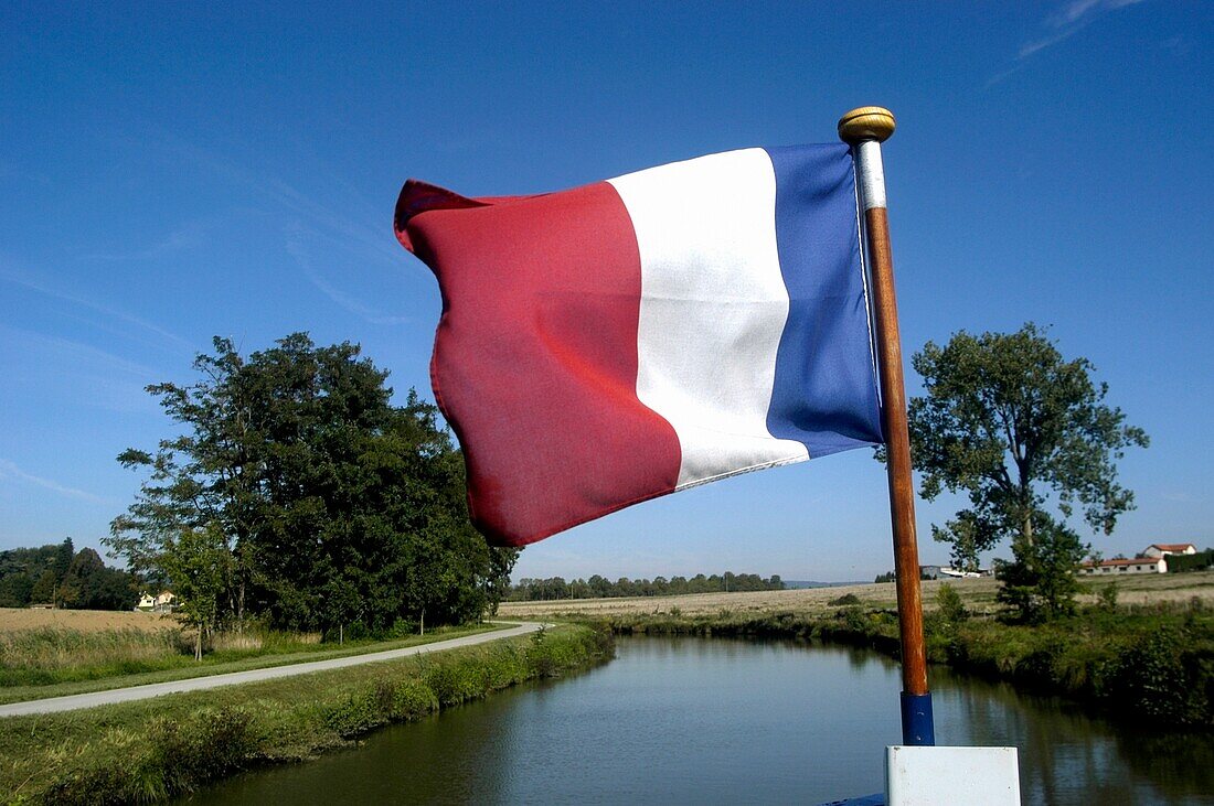 Eine französische Peniche, mit französischer Flagge, auf dem Canal Due Centre