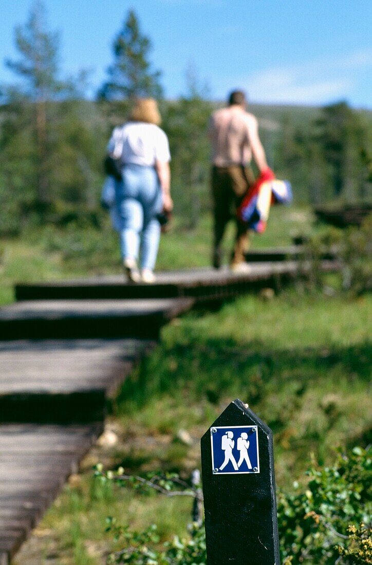 Couple Walking On Wooden Path