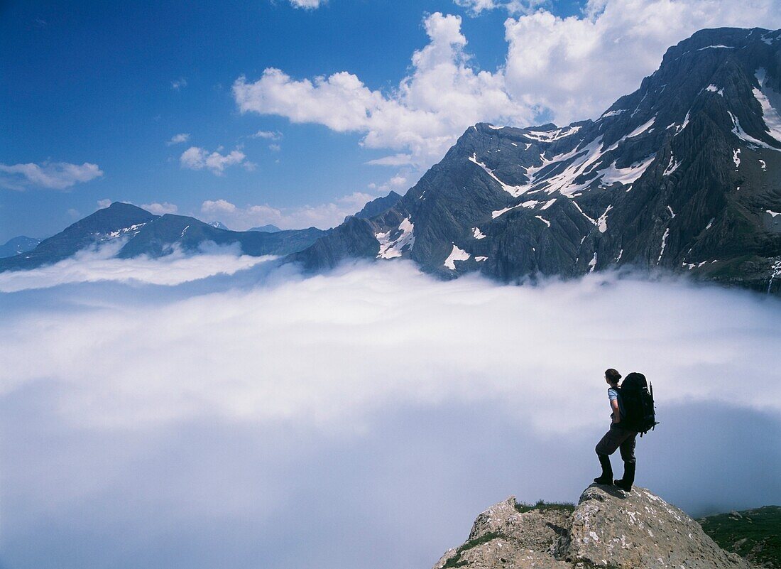 Walker On The Edge Of A Cliff Amongst The Clouds At Cirque De Gavarnie