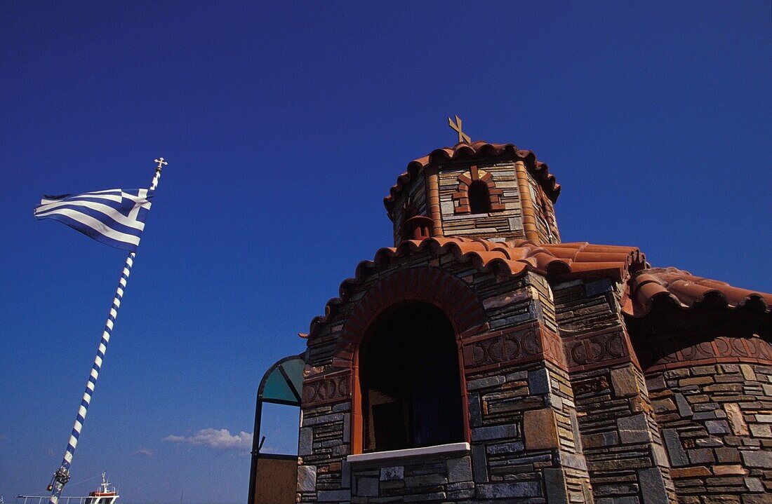 Kleine Kirche und griechische Flagge