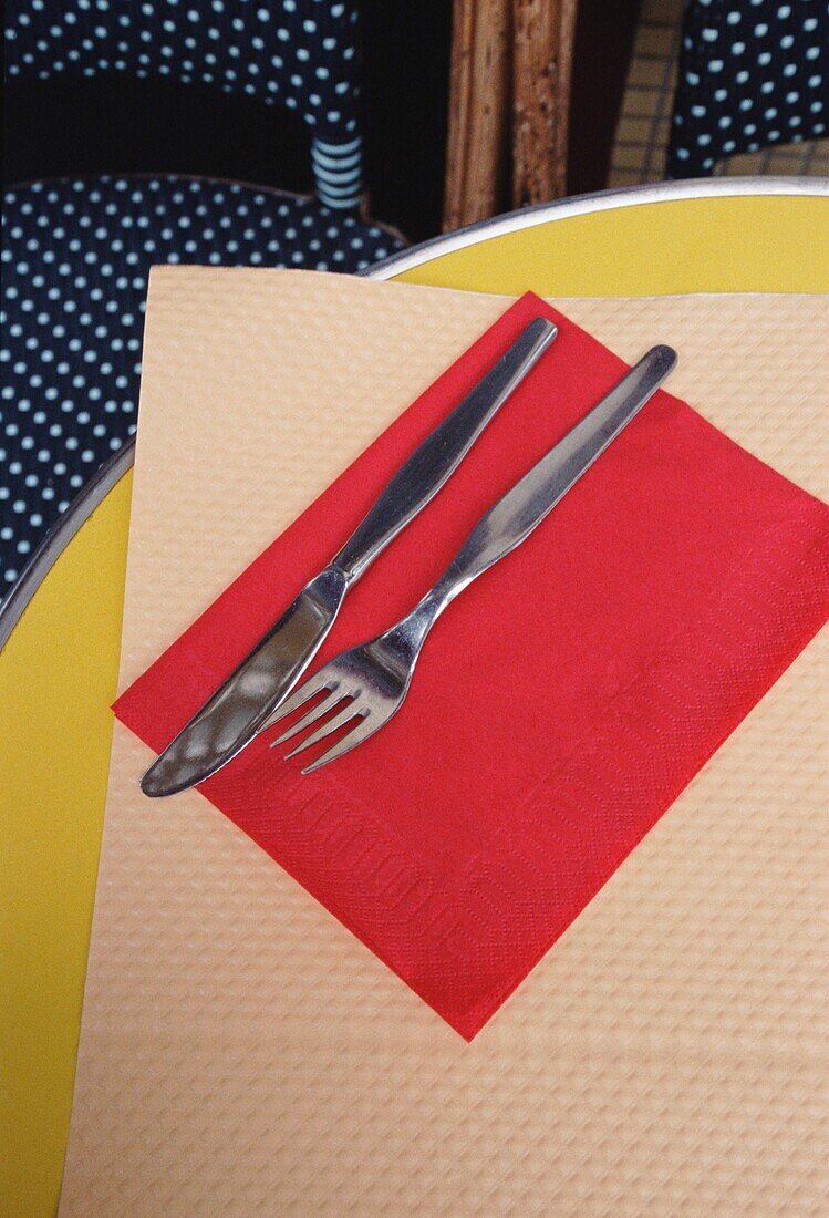Detail eines Messers mit Gabel auf einer Serviette auf einem Tisch in einem Cafe