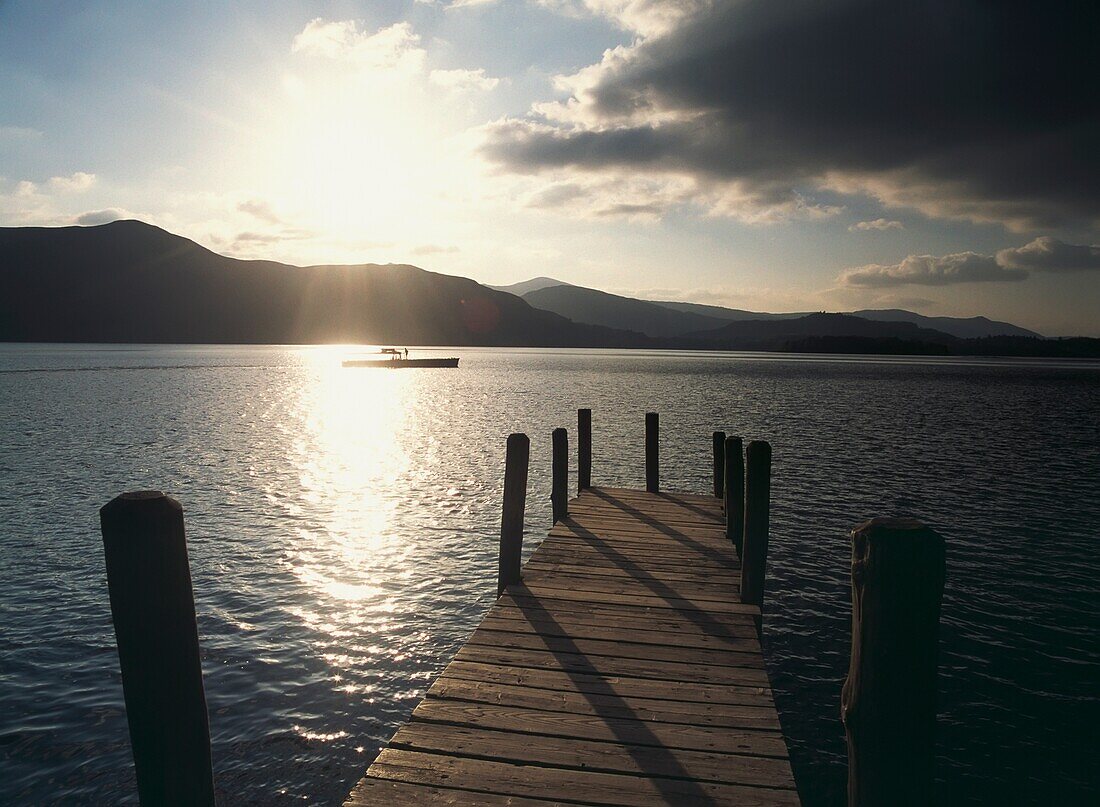 Blick über den Holzsteg auf das Boot in der Abenddämmerung auf dem Derwent Water