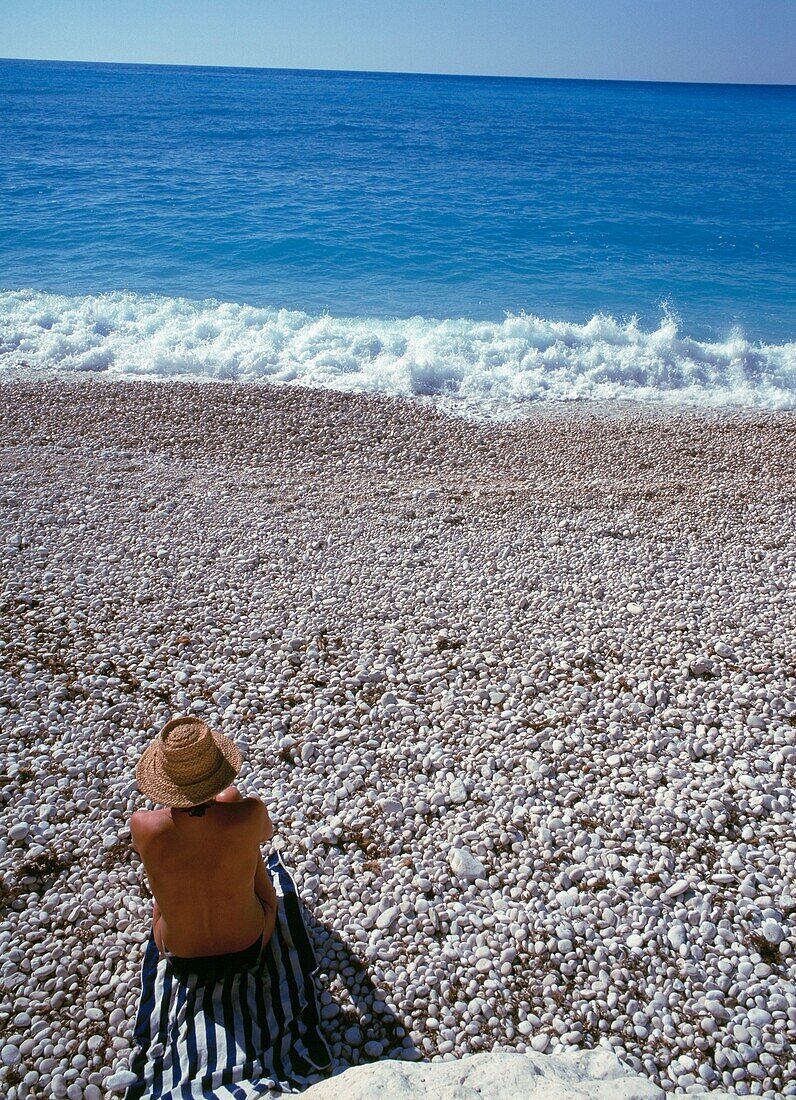 Frau beim Sonnenbaden am Strand von Myrtos
