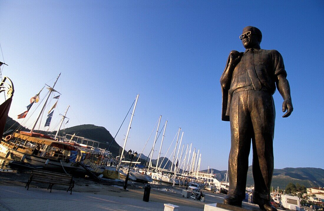 Statue von Aristoteles Onassis, lokaler Hafen im Hintergrund