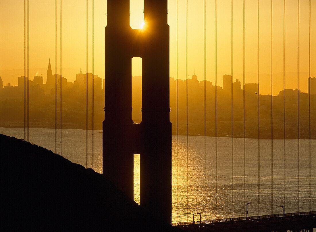 Sonnenaufgang hinter der Golden Gate Bridge mit der Skyline dahinter