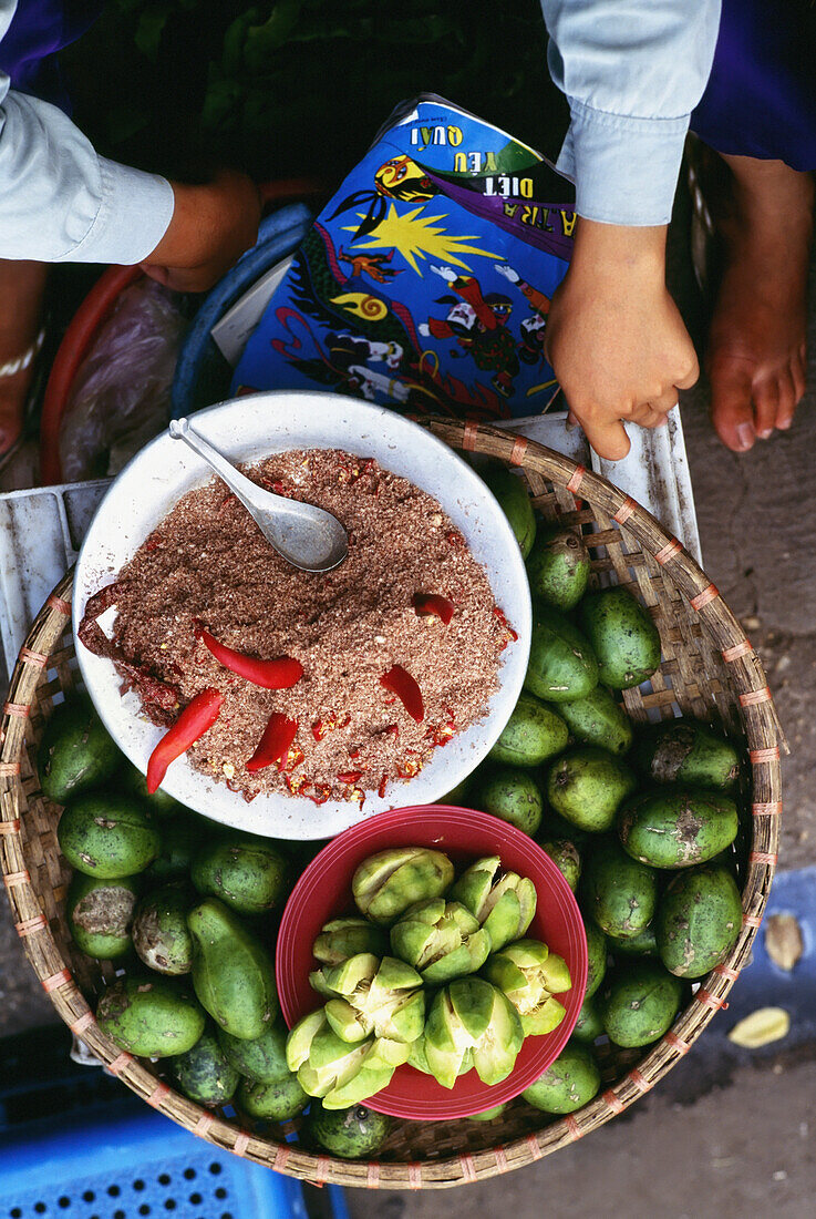 Frau verkauft Guave, Salz und Chilis auf einem Markt in Hanoi