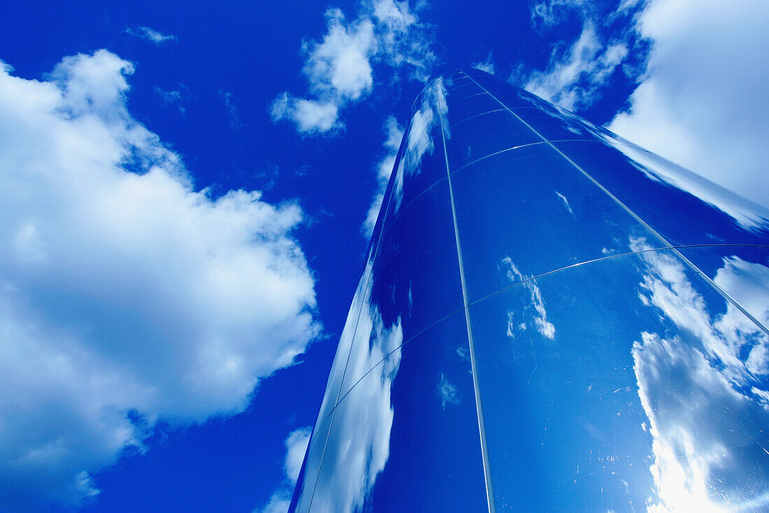 Obelisk aus Glas mit blauem Himmel und Wolkenreflexionen