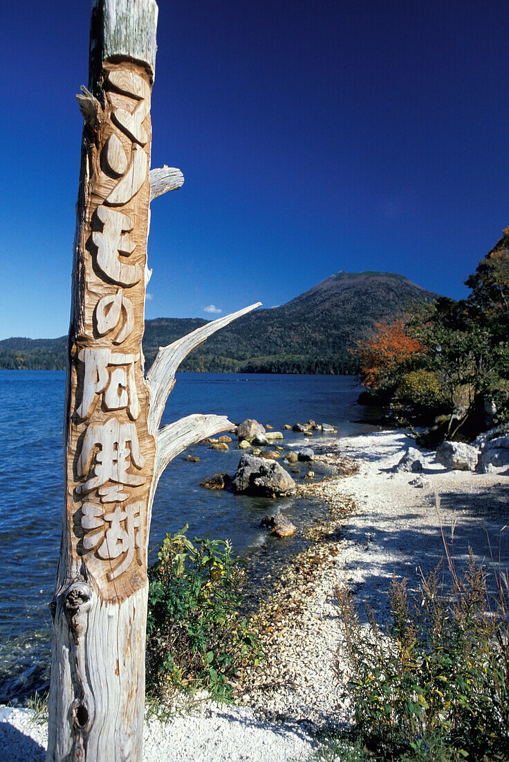 Totempfahl und Landschaft am Rande des Akan-Sees