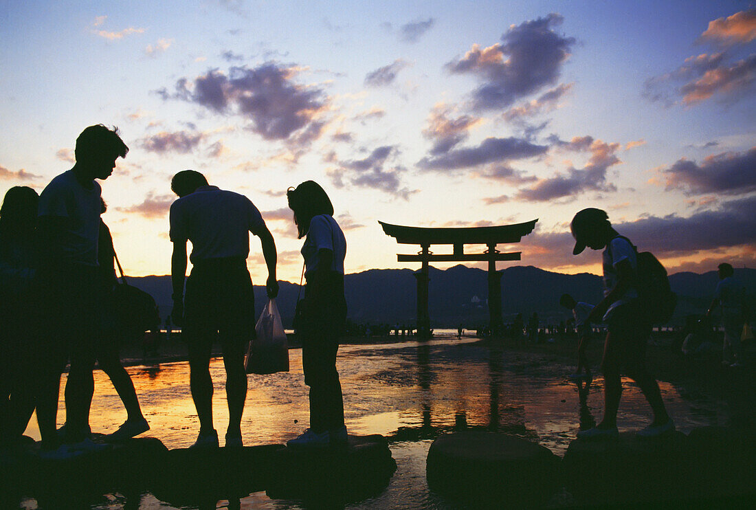 Familie am Itsukushima-Schrein in der Abenddämmerung