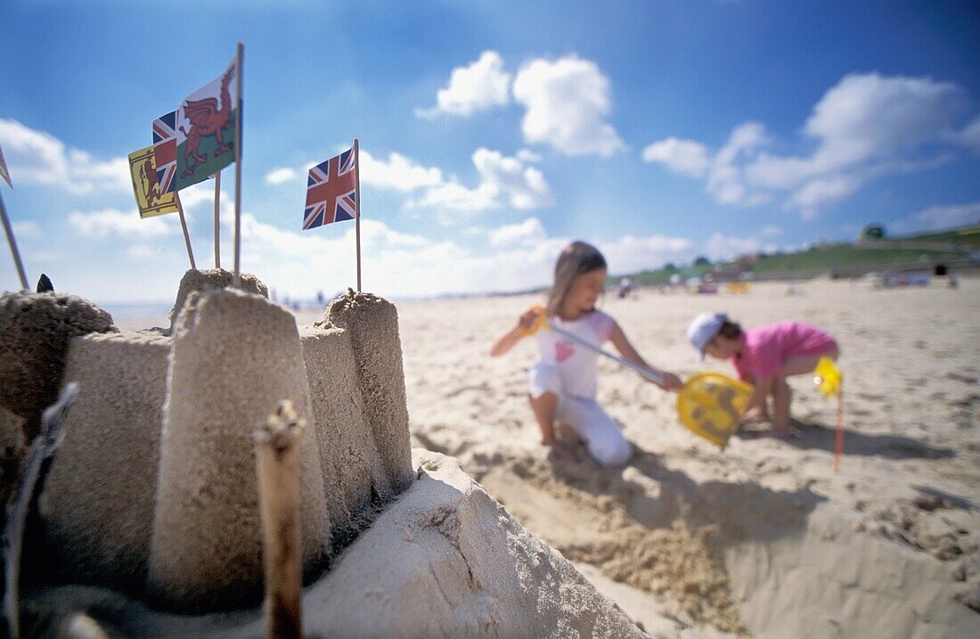 Mädchen am Strand bauen eine Sandburg