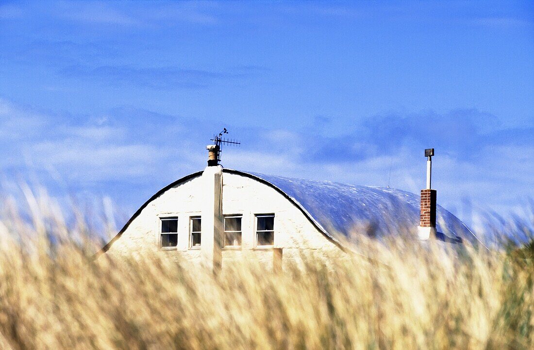 Haus entlang der Küste, verdeckt durch Gras
