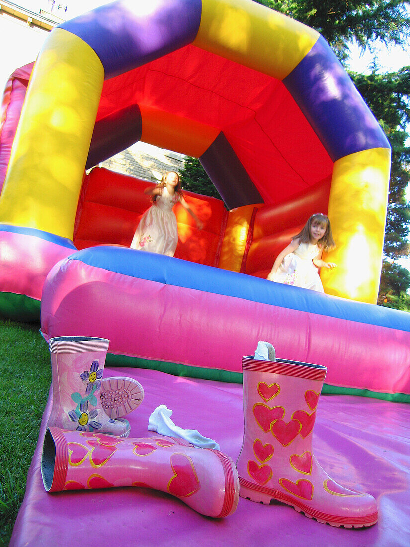 Two Girls Playing On An Inflatable Bouncy Castle