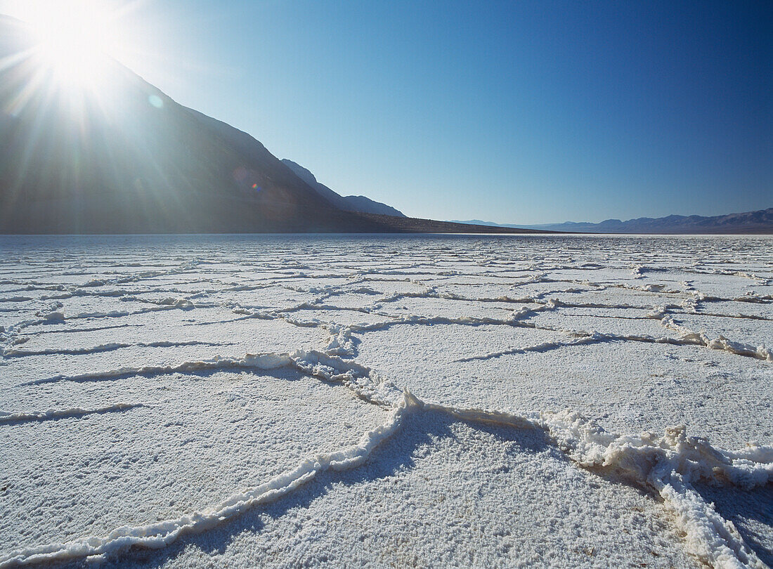 Looking Across The Saltpans Early In The Morning With Sun Shining Over Mountain