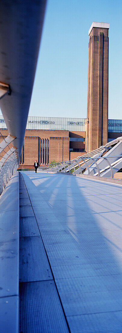 Ein Mann geht über die Millennium Bridge mit der Tate Modern im Hintergrund