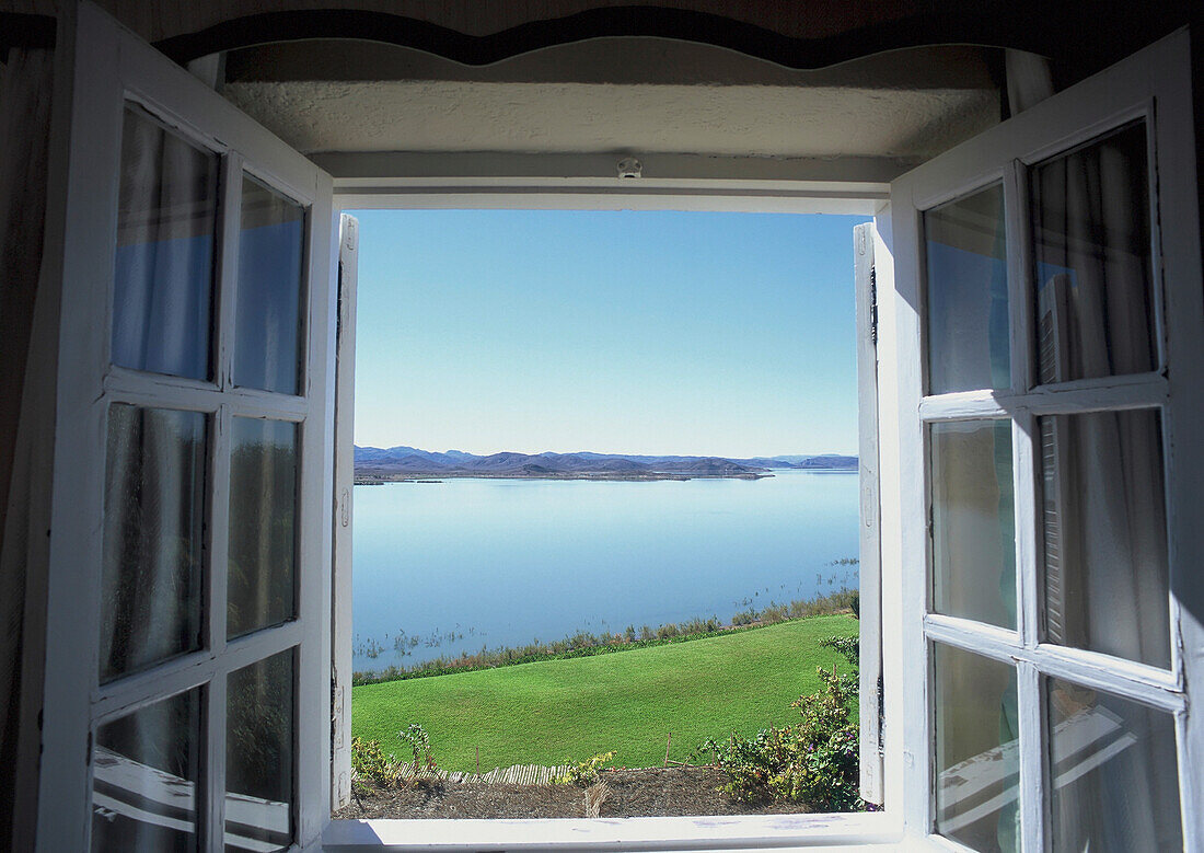 Blick durch ein Fenster auf einen See