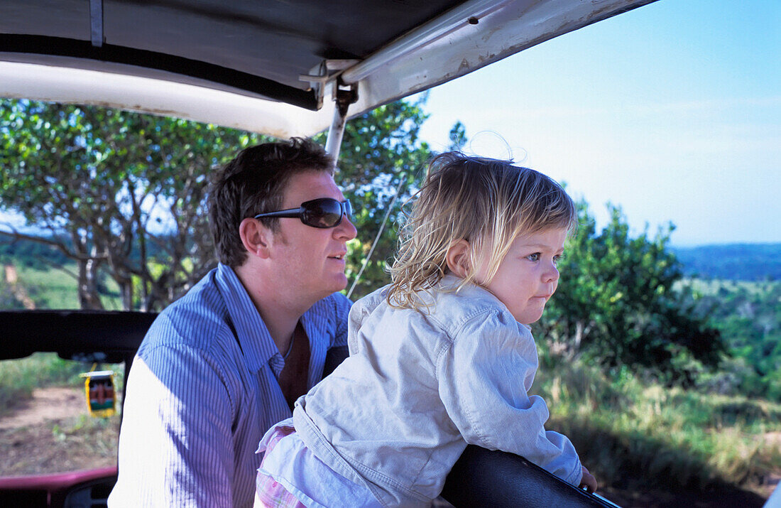 Vater und junge Tochter auf Safari im Jeep