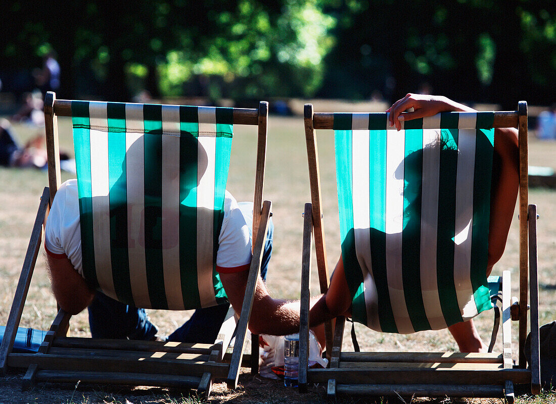 Ein schlafendes Paar auf Liegestühlen im Green Park