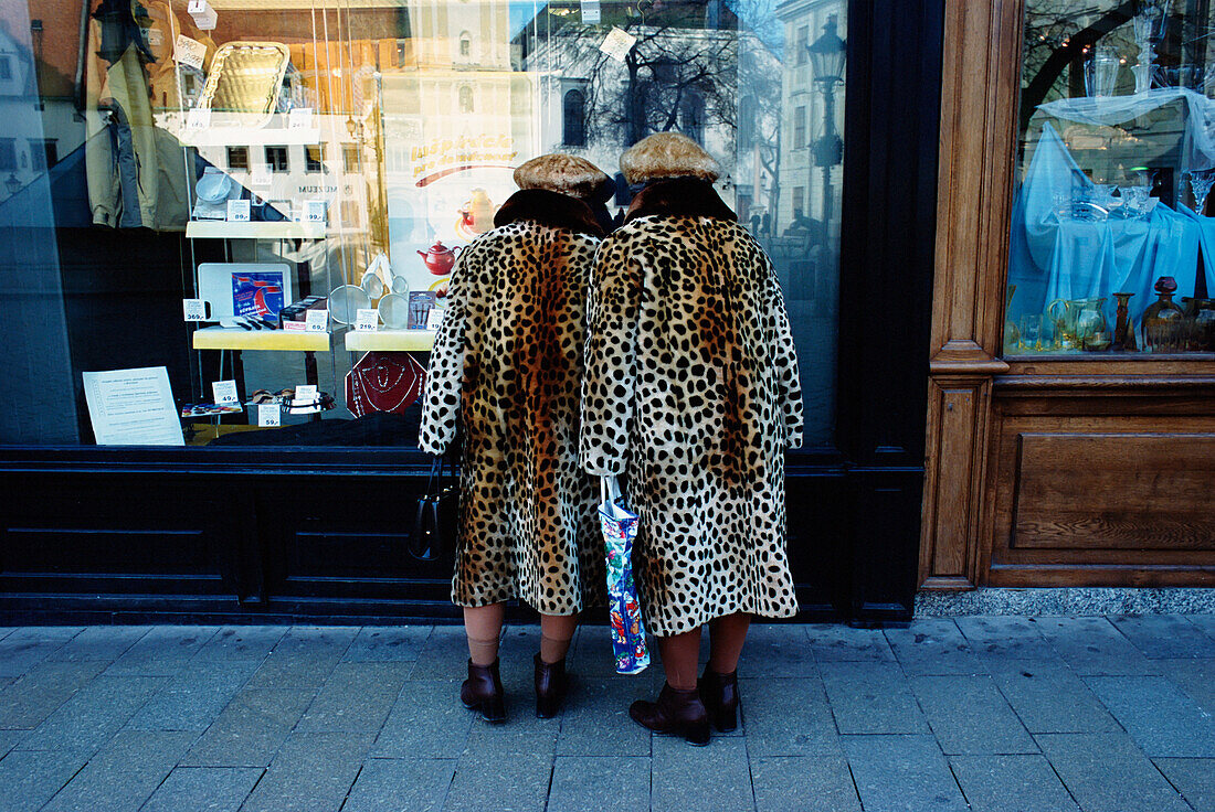 Damen in passenden Pelzmänteln beim Schaufensterbummel in der Altstadt