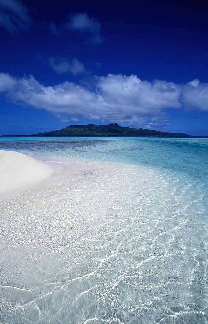 Klares Wasser am tropischen Strand mit Insel im Hintergrund