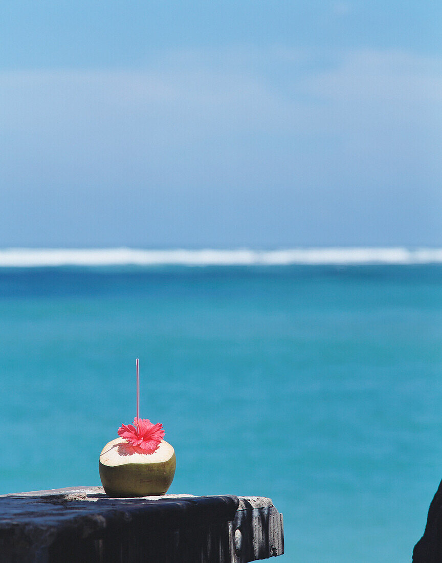 Cocktail in einer Kokosnuss am Meer