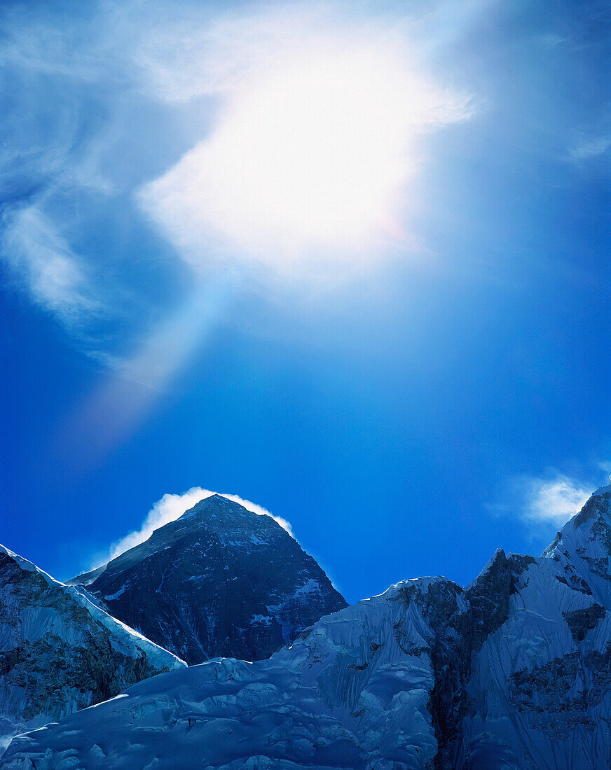 Nepal, Sagamatha-Nationalpark, Mount Everest und Sonne, die durch die Wolken scheint; Solu Khumbu