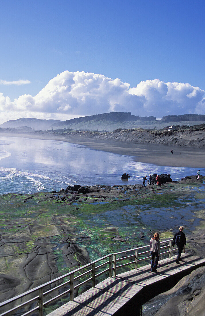 Couple Walking On Wooden Walkway By Coast, High Angle View